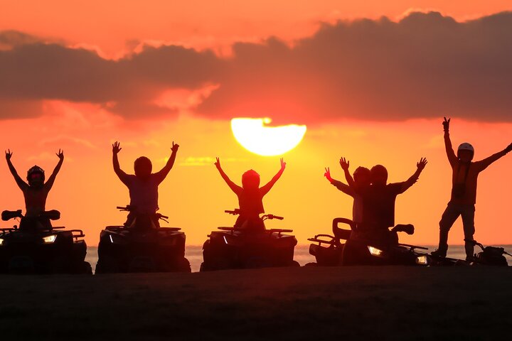 Riders silhouetted against a desert sunset