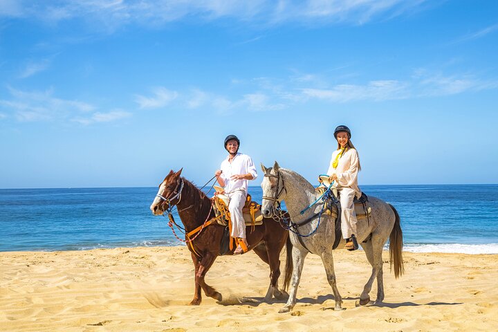 Horseback riders on the sand