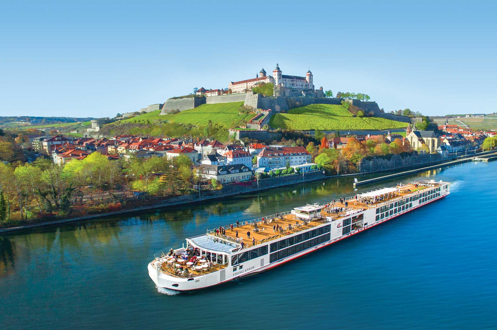River ship passing a hillside town