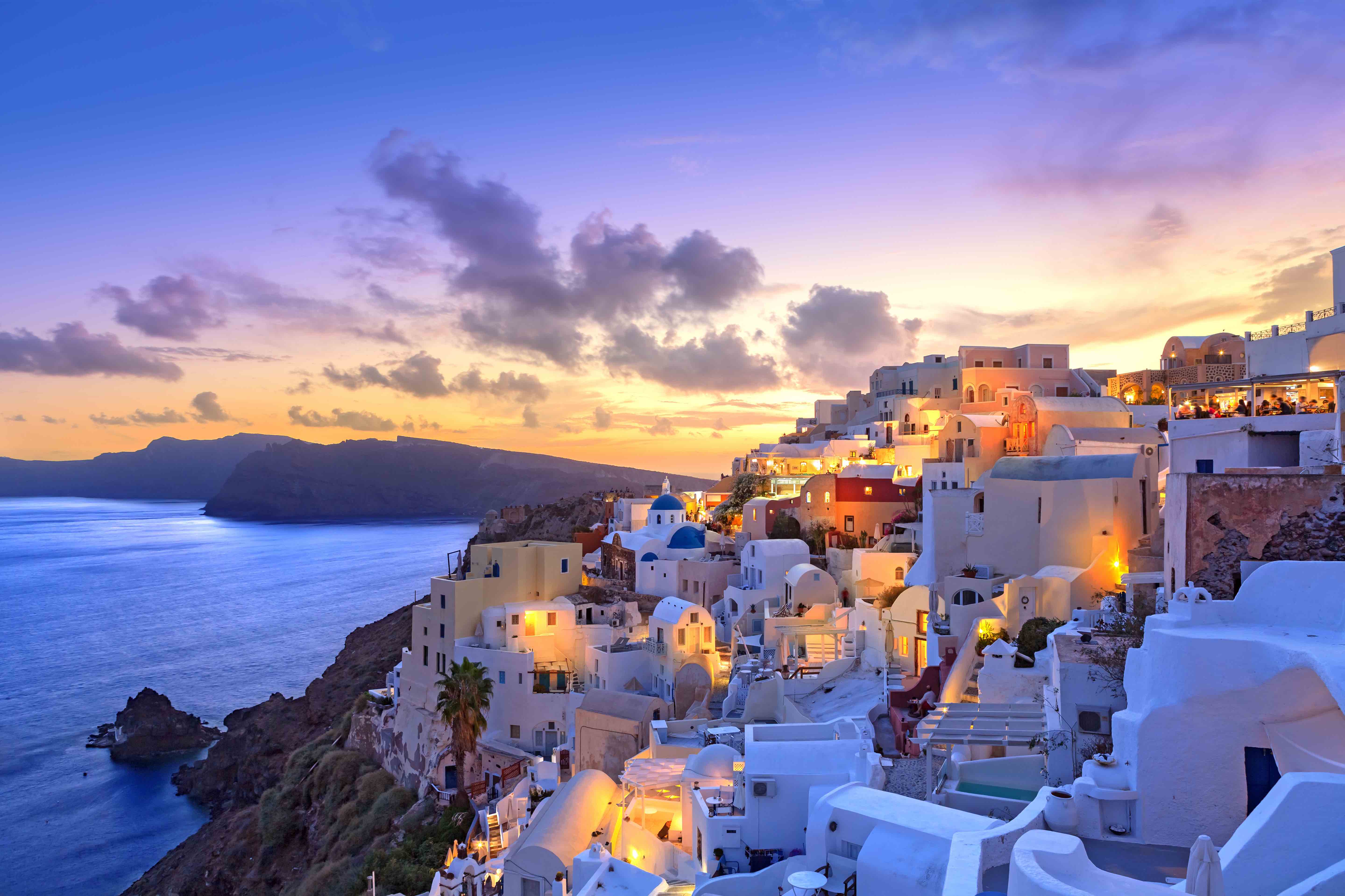 Whitewashed cliffside town at sunset